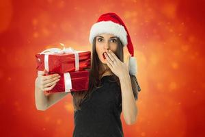 Surprised Girl in santa hat with red gift photo