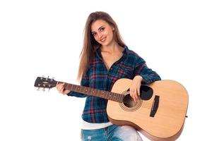 alegre joven morena tocando la guitarra foto