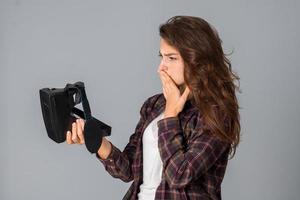 funny young brunette girl testing virtual reality glasses photo