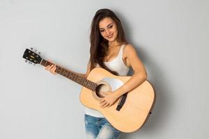 mujer con guitarra mirando hacia otro lado y sonriendo foto