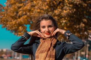 young girl is standing on the street and raised her hands to the face photo