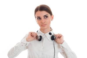 young call office girl in white shirt with headphones isolated on  background in studio photo