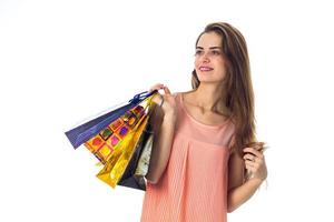 cute girl holds in hand a lot of different packages and smiling isolated on white background photo