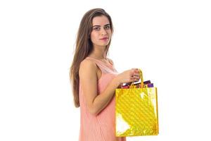 young girl stands sideways and holding large yellow package izoliovano on  white background photo