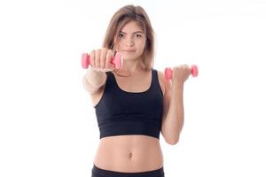 Fitness woman a stretched out  hand with  small dumbbell photo