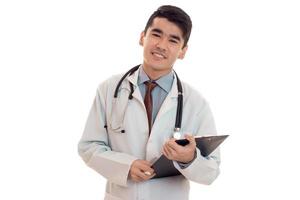 Retrato de estudio de feliz médico masculino en uniforme posando aislado sobre fondo blanco.