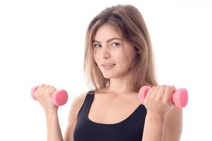 close-up of a smiling sporty girl who holds in her hands the two dumbbells photo