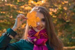 Portrait of a young smiling girl that keeps the sheet near the eye close-up photo