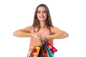 cheerful young girl keeps two hands different colored packages with purchases and smiling photo