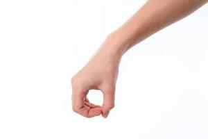 mano femenina bajada con los dedos apretados en términos de aislamiento en fondo blanco foto