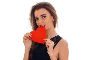 Seductive young brunette woman with red heart in hands posing isolated on white background. Saint Valentine's day concept. Love concept. photo