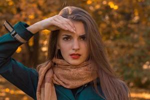 Portrait of beautiful woman in scarf that keeps your hand near hair closeup photo