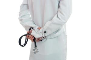 male doctor with stethoscope in hands posing in uniform isolated on white background photo