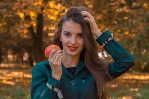 pin-up girl holds an Apple in his hand and improves hair closeup photo