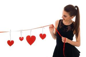 young beauty woman with red lips preparing to celebrate valentines day with heart symbol in studio isolated on white background photo