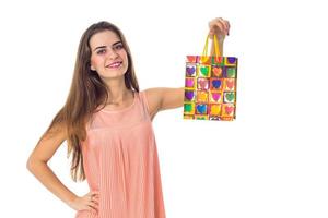 young girl stands up straight keeps one hand on the side and the second  rose package  smiling isolated  white background photo