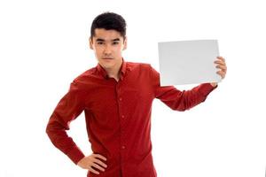 portrait of serious young brunette male model with placard in hands isolated on white background photo