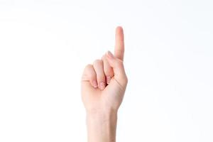 mano femenina que muestra el gesto con un dedo levantado aislado en fondo blanco foto