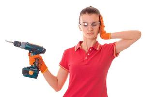 young brunette woman builder makes renovation with drill in her hands isolated on white background photo