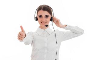 Chica de oficina de centro de llamadas joven sexy con auriculares y micrófono mirando a la cámara sonriendo y mostrando los pulgares hacia arriba aislado sobre fondo blanco. foto