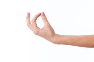 mano femenina extendida hacia un lado y mostrando el gesto con dos dedos entrelazados foto