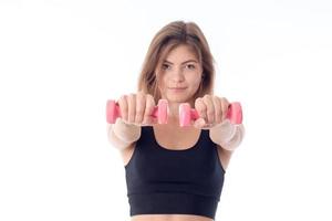 young girl in a black sports top holding dumbbells photo
