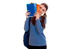 cutie young students girl with backpack and folders for notebooks in her hands looking at the camera and smiling isolated on white background photo