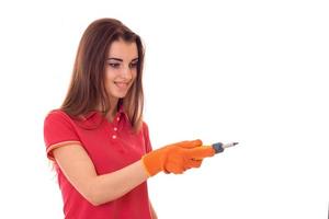 portrait of young cute brunette builder girl makes renovation with screwdriver in hands isolated on white background photo