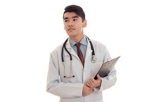 pretty elegant doctor in uniform with stethoscope smiling on camera with board in hands isolated on white background photo