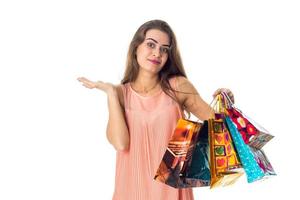 cute girl spreads her hand and holds the multicolored bags isolated on white background photo