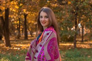 beautiful girl with large, bright scarf on the shoulders and smiles photo