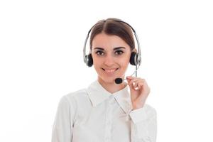 joven mujer de negocios feliz con auriculares y micrófono mirando a la cámara y sonriendo aislada de fondo blanco foto