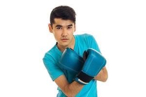 Morena seria deportista practicando boxeo en guantes azules aislados en fondo blanco foto