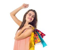 cheerful young girl raised her hand up and the other  holds  lot of packets with gifts is isolated on  white background photo