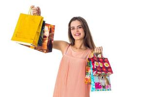 young beautiful girl smiles and raises great colour packages isolated on white background photo