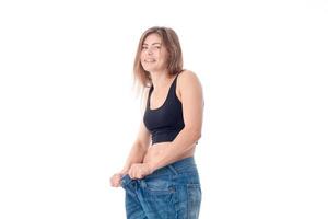 cheerful young girl wore large trousers and laughs is isolated on  white background photo