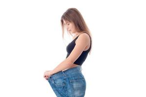 slender girl stands sideways in large wide jeans isolated on white background photo