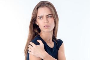 young girl looks away and keeps  hand on the shoulder is isolated   white background photo