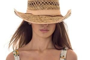 close up portrait without eyes of beautiful young brunette woman with straw hat posing isolated on white background photo