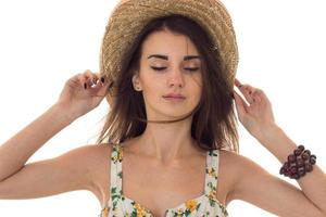 young sensual woman with closed eyes posing with straw hat isolated on white background photo