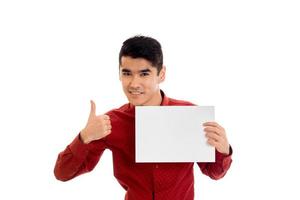 a young guy in a red shirt holding a white paper isolated on white background photo