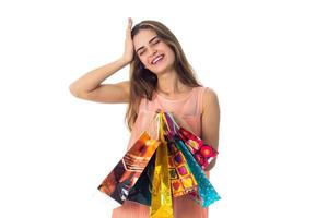 young girl closed her eyes smiling and holding a colored bags isolated on white background photo