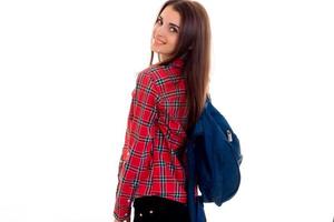 cute young girl with a backpack and a Plaid Shirt is worth turning back forward photo