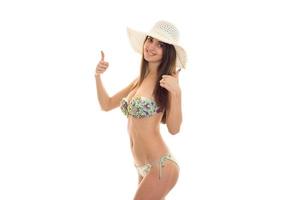 a young girl in a bathing suit and hat worth turning sideways and shows the class photo