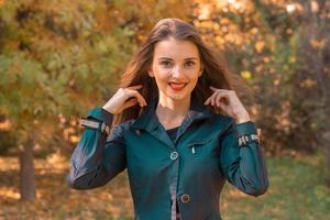 Merry girl stands on a street in the sunshine and raised hands photo