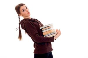 young girl-teen stands sideways and holds many books photo