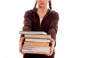 Teen girl with pigtails stretches forward many books isolated on white background photo