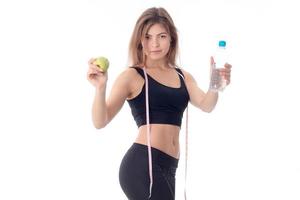 slim girl in a black top stretched out both hands forward shows  fruit and  bottle of water photo