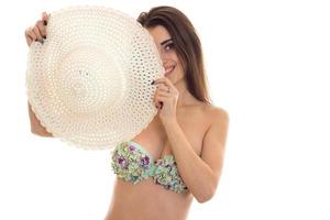 sexy young girl in a bathing suit covers his face hat and smiling photo