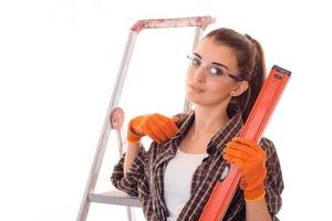 beautiful young girl in transparent protective glasses holding tool isolated on white background photo